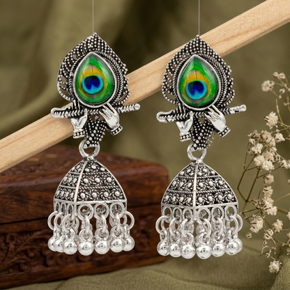 Silver Peacock Feather Jhumka Earrings – Krishna Flute Motif & Filigree Beads