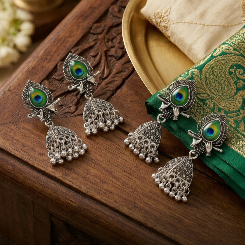 Silver Peacock Feather Jhumka Earrings – Krishna Flute Motif & Filigree Beads