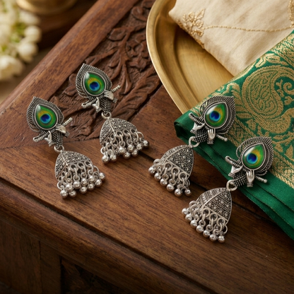 Silver Peacock Feather Jhumka Earrings – Krishna Flute Motif & Filigree Beads